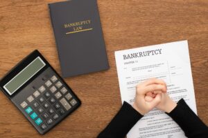 cropped view of female clenched hands on bankruptcy papr with concept of Chapter 11 Bankruptcy: Navigating Proof of Claim for Creditors
